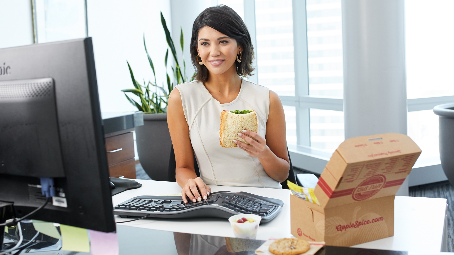 Office Employee Enjoying a Catered Apple Spice Boxed Lunch at Desk