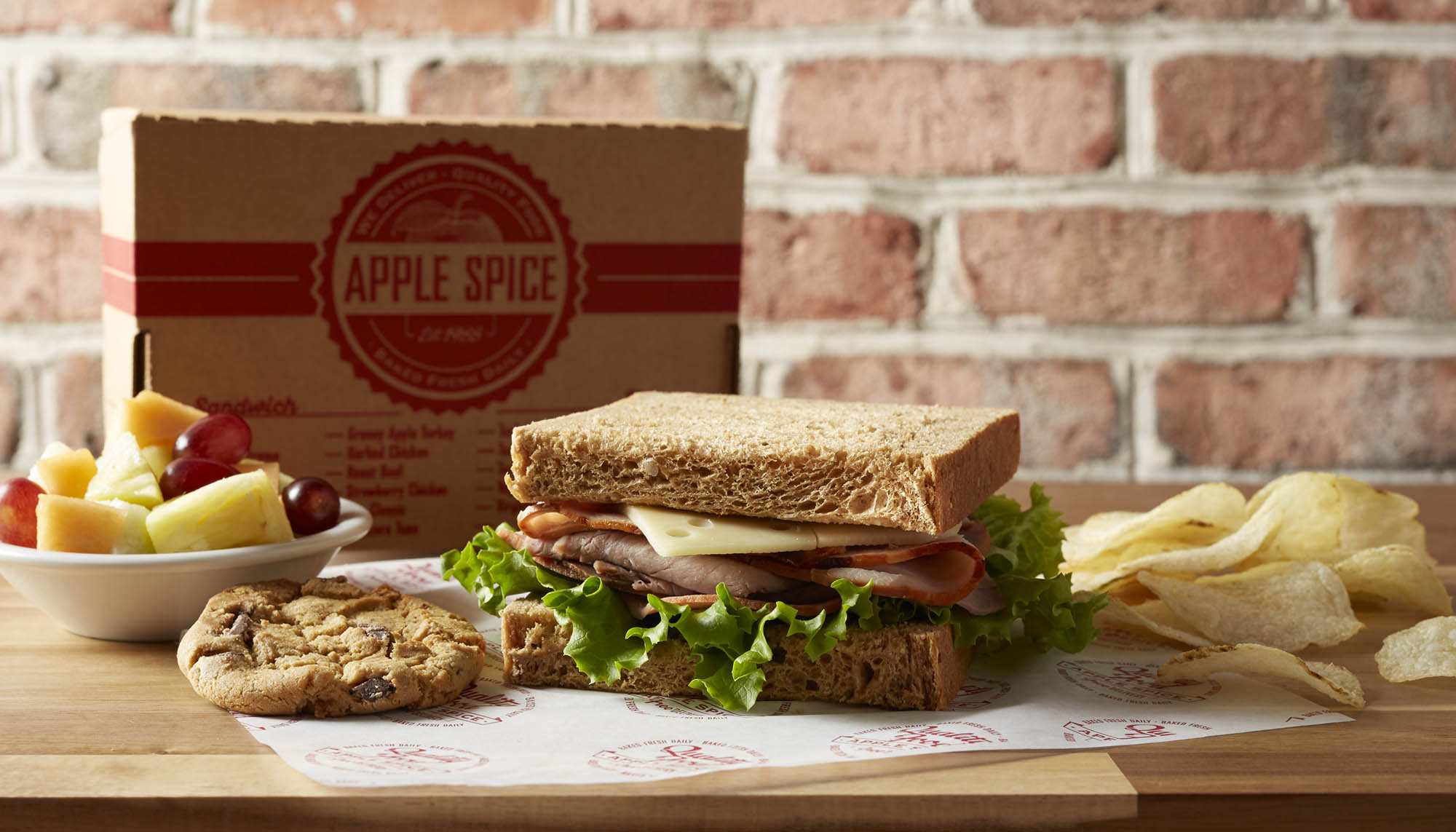 roast beef sandwich with chips, cookie, and fruit